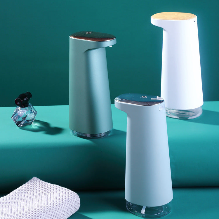 Three soap dispensers on a teal surface with a green background
